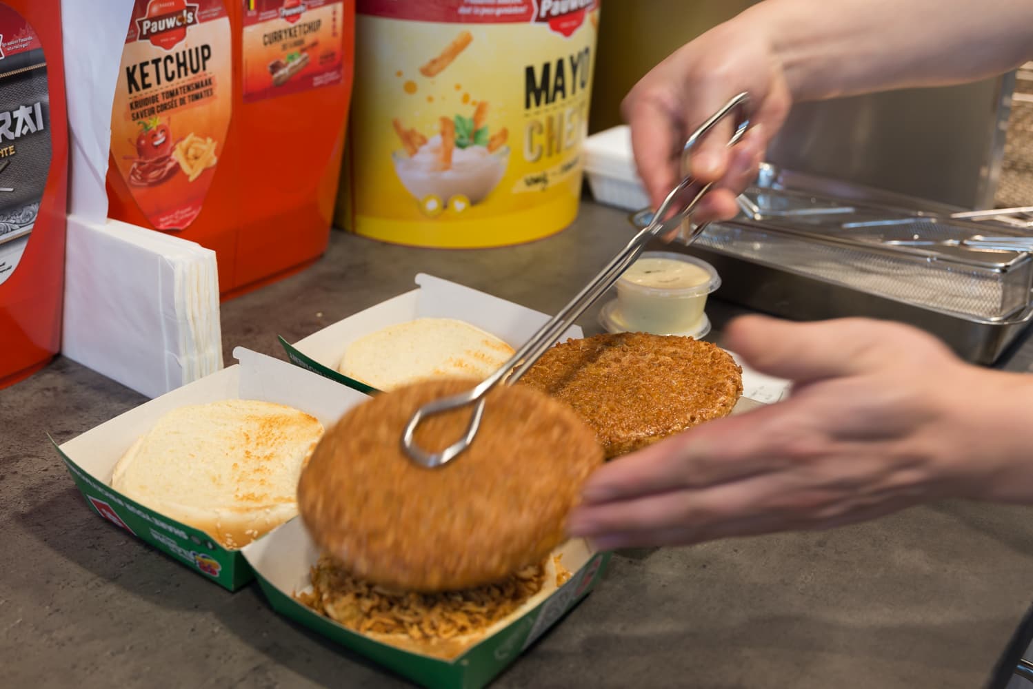 Een burger wordt vers bereid aan de toonbank