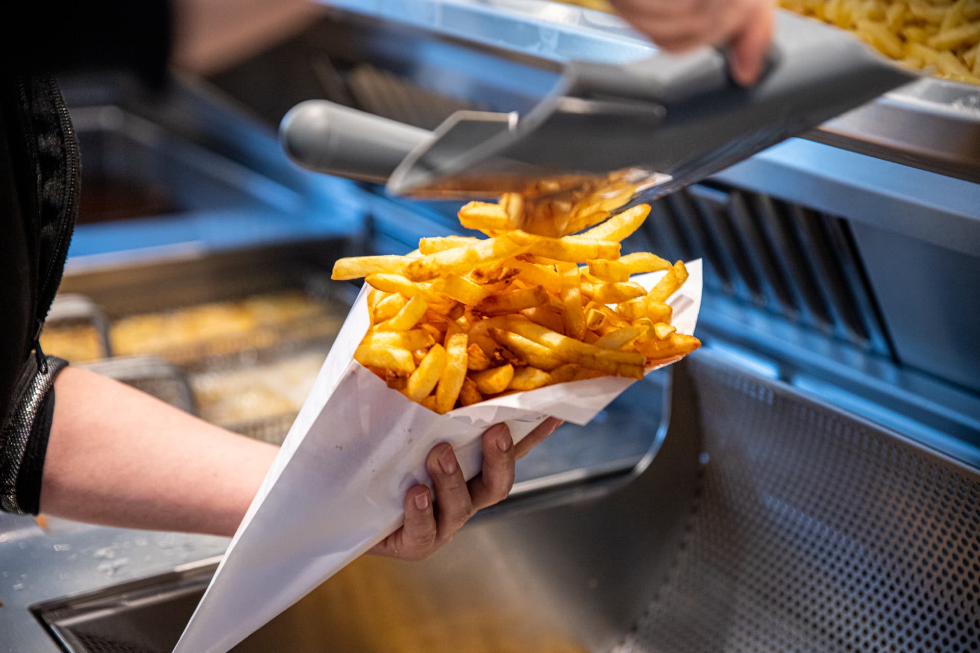Verse frieten worden in een puntzak geschept