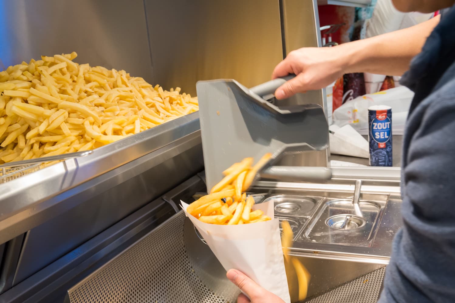 Verse frieten worden in een puntzak geschept